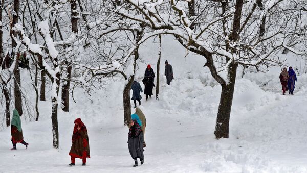 People walk through a snow-covered orchard to attend the funeral of Adil Ahmad, a suspected militant, who according to local media was killed in a gun battle with Indian soldiers, in Dalwan village in central Kashmir's Budgam district January 14, 2020 - Sputnik International