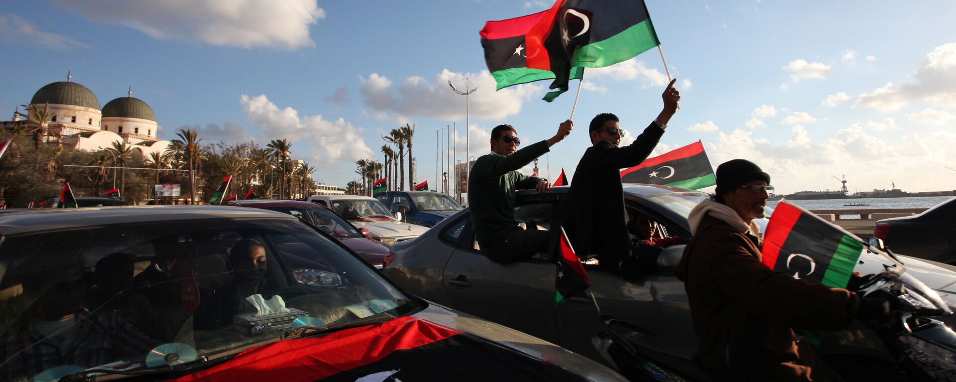 Libyans wave the national flag during commemorations to mark the second anniversary of the revolution that ousted Moammar Gadhafi in Benghazi, Libya, Friday, Feb, 15, 2013 - Sputnik International, 1920, 21.12.2021