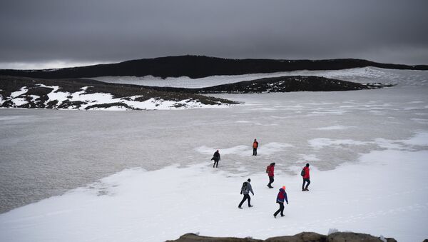 People walk on snow atop the Ok volcano crater on their way to a ceremony  by the area which once was the Okjokull glacier, in Iceland - Sputnik International