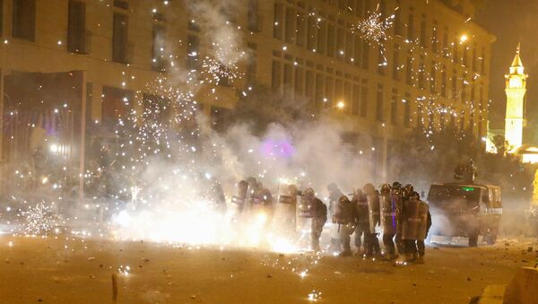 Fireworks are set off in front of police officers standing in postion behind riot shields during a protest against a ruling elite accused of steering Lebanon towards economic crisis in Beirut, Lebanon January 18, 2020.  - Sputnik International