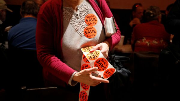 A member of the Virginia Citizens Defense League distributes Guns Save Lives stickers during the organization's Sunday dinner before their Monday rally at Virginia's Capitol, in Henrico, Virginia, U.S. January 19, 2020 - Sputnik International
