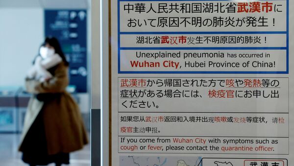 A woman wearing a mask walks past a quarantine notice about the outbreak of coronavirus in Wuhan, China at an arrival hall of Haneda airport in Tokyo, Japan, January 20, 2020 - Sputnik International