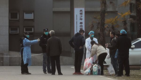 Medical staff and security personnel stop patients' family members from getting too close to the Jinyintan hospital, where patients with pneumonia caused by the new strain of coronavirus are being treated, in Wuhan, Hubei province, China, 20 January 2020 - Sputnik International