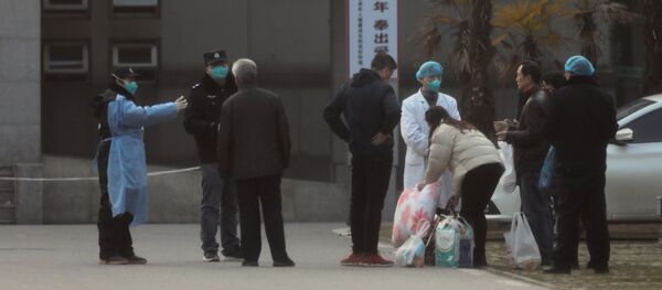 Medical staff and security personnel stop patients' family members from getting too close to the Jinyintan hospital, where patients with pneumonia caused by the new strain of coronavirus are being treated, in Wuhan, Hubei province, China, 20 January 2020 - Sputnik International
