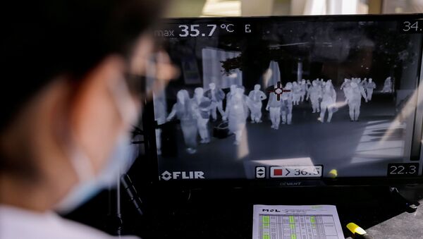 Airport personnel monitor a thermal scanner as passengers arrive at the Ninoy Aquino International Airport in Pasay, Philippines, January 23, 2020 - Sputnik International