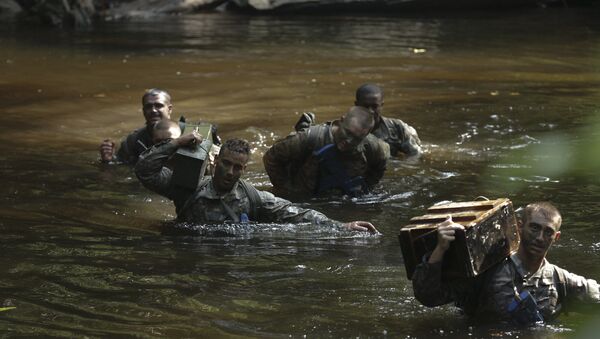 U.S. Army Soldiers assigned to Bravo Co. 3rd Battalion, 7th Infantry Regiment, 2nd Infantry Brigade Combat Team, 3rd Infantry Division carry equipment through a pond during the team obstacle course at the French Jungle Warfare School near Yemen, Gabon, June 9, 2016. - Sputnik International
