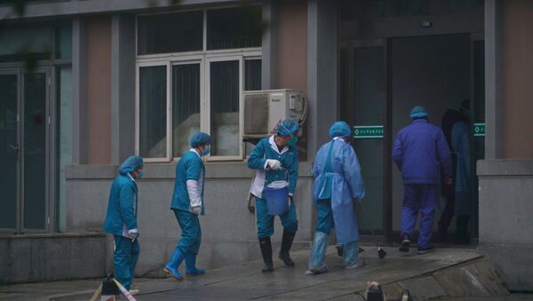 Hospital staff wash the emergency entrance of Wuhan Medical Treatment Center, where some infected with a new virus are being treated, in Wuhan, China, Wednesday, Jan. 22, 2020. - Sputnik International