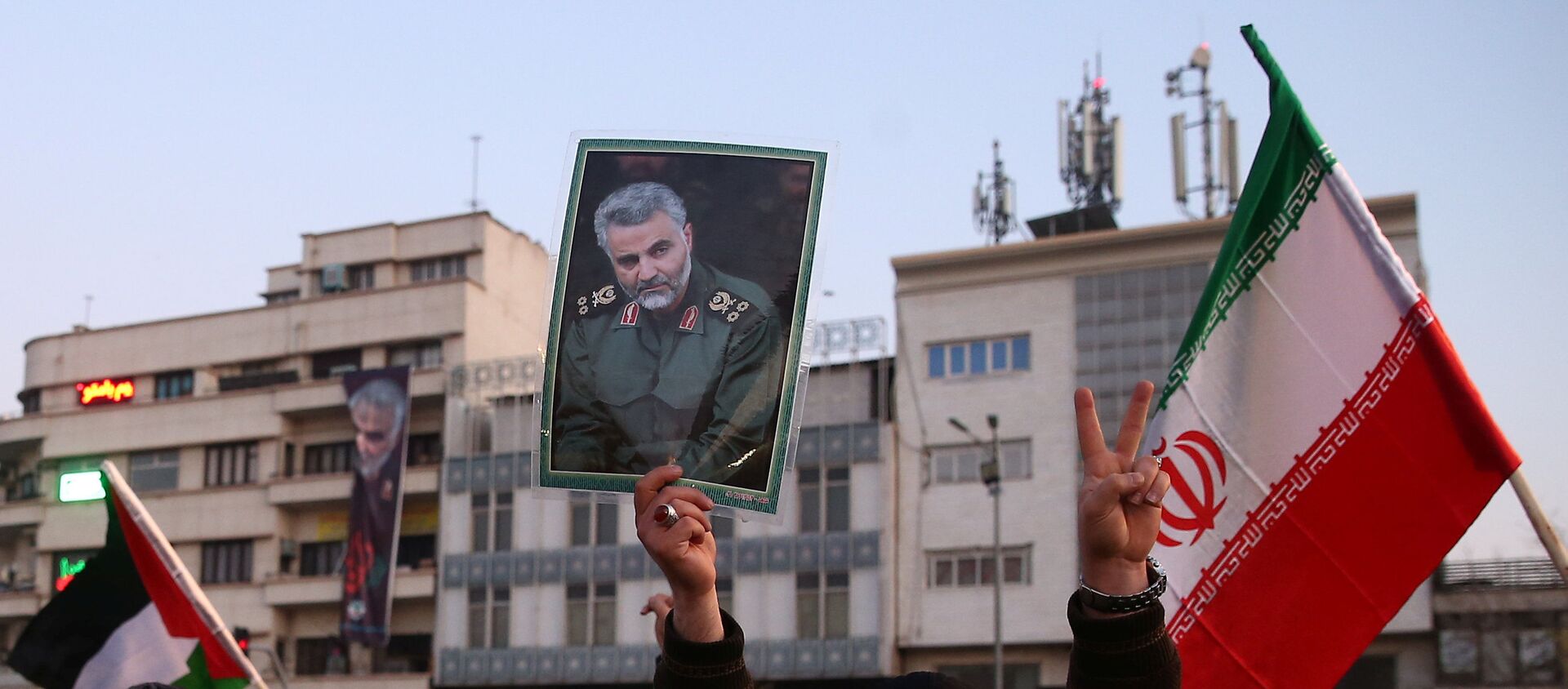 A man holds a picture of late Iranian Major-General Qassem Soleimani, as people celebrate in the street after Iran launched missiles at U.S.-led forces in Iraq, in Tehran, Iran - Sputnik International, 1920, 07.02.2020