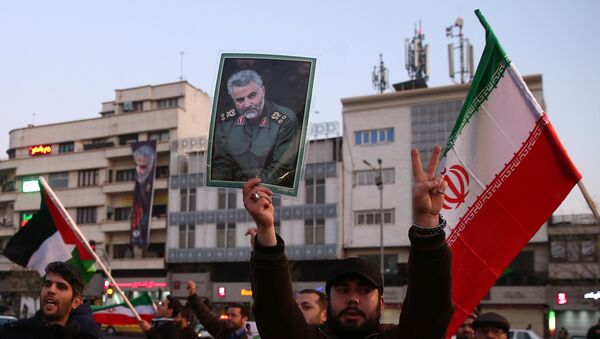 A man holds a picture of late Iranian Major-General Qassem Soleimani, as people celebrate in the street after Iran launched missiles at U.S.-led forces in Iraq, in Tehran, Iran - Sputnik International