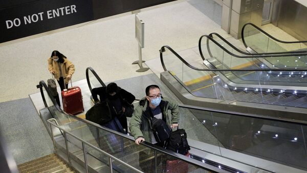 A traveller wearing a mask arrives on a direct flight from China - Sputnik International