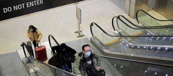 A traveller wearing a mask arrives on a direct flight from China - Sputnik International