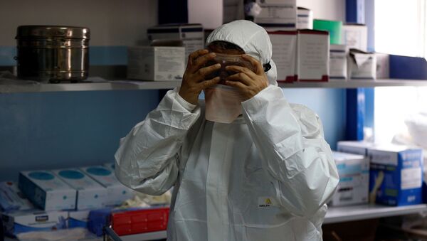 A member of the medical staff puts on protective gear at a new section specialised in receiving any person who may have been infected with coronavirus, at the Al-Bashir Governmental Hospital in Amman, Jordan January 28, 2020 - Sputnik International