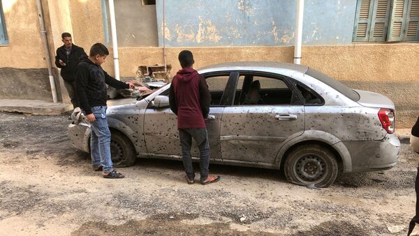 Libyan boys check a damaged car after a shell fell on a residential area at Hadba al-Badri district, in Tripoli - Sputnik International
