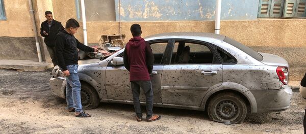 Libyan boys check a damaged car after a shell fell on a residential area at Hadba al-Badri district, in Tripoli - Sputnik International