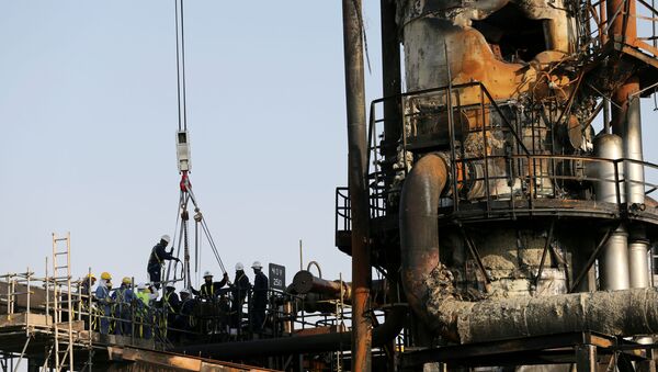  Workers are seen at the damaged site of Saudi Aramco oil facility in Abqaiq, Saudi Arabia - Sputnik International