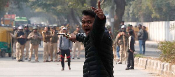 An unidentified man reacts as he brandishes a gun during a protest against a new citizenship law outside the Jamia Millia Islamia university in New Delhi, India, January 30, 2020 An unidentified man reacts as he brandishes a gun during a protest against a new citizenship law outside the Jamia Millia Islamia university in New Delhi, India, January 30, 2020 - Sputnik International