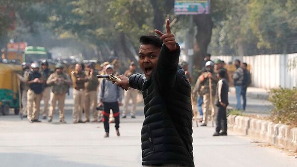 An unidentified man reacts as he brandishes a gun during a protest against a new citizenship law outside the Jamia Millia Islamia university in New Delhi, India, January 30, 2020 - Sputnik International