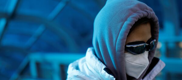 A woman wearing a face mask and goggles uses an escalator near Beijing Railway Station A woman wearing a face mask and goggles uses an escalator near Beijing Railway Station - Sputnik International