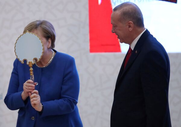 German Chancellor Angela Merkel receives a gift from Turkish President Tayyip Erdogan during the official opening ceremony of Turkish-German University's new campus in Istanbul, Turkey, January 24, 2020. - Sputnik International