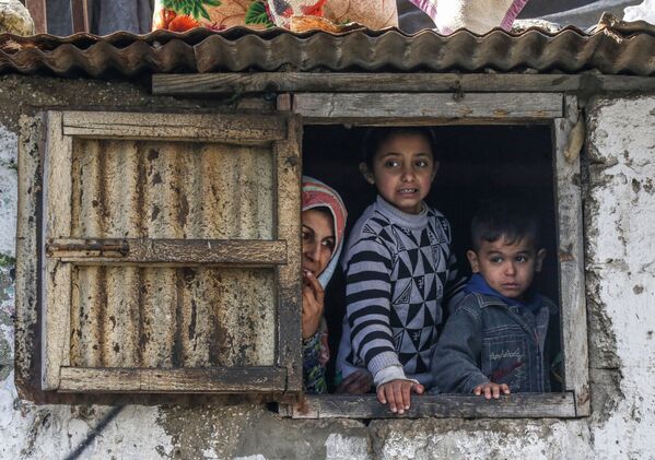 A Palestinian family looks on at the Khan Yunis refugee camp in the southern Gaza Strip on January 28, 2020. - Sputnik International