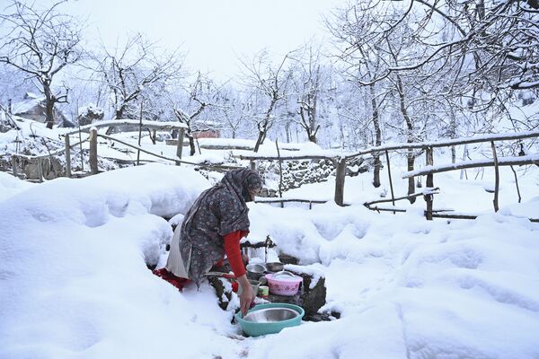 A woman washes utensils after a snowfall in the outskirts of Srinagar on January 29, 2020. - Sputnik International