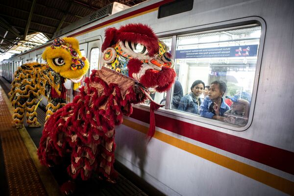 Passengers look from the window of a train as Lion-dances perform at a platform of Gambir station during Chinese Lunar New Year of the Rat celebrations in Jakarta, Indonesia, January 25, 2020 in this photo taken by Antara Foto.   - Sputnik International