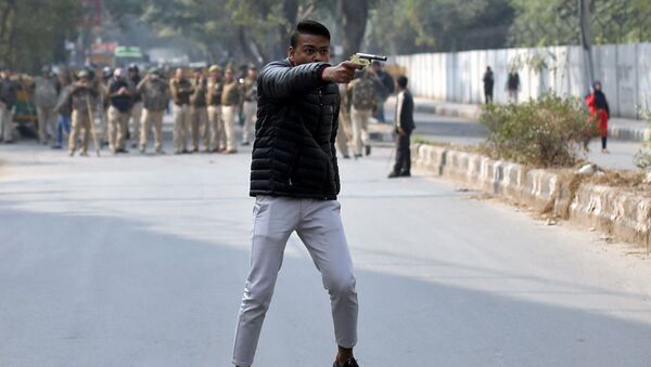 An unidentified man brandishes a gun during a protest against a new citizenship law outside the Jamia Millia Islamia university in New Delhi, India, January 30, 2020.  - Sputnik International