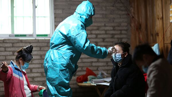 A medical worker in protective suit takes body temperature measurement of a villager as the country is hit by an outbreak of the new coronavirus, in Danzhai county, Qiandongnan Miao and Dong Autonomous Prefecture, Guizhou province, China January 31, 2020. Picture taken January 31, 2020. - Sputnik International