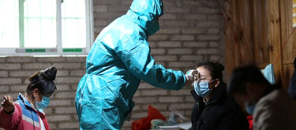 A medical worker in protective suit takes body temperature measurement of a villager as the country is hit by an outbreak of the new coronavirus, in Danzhai county, Qiandongnan Miao and Dong Autonomous Prefecture, Guizhou province, China January 31, 2020. Picture taken January 31, 2020. - Sputnik International