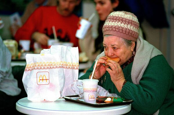 An elderly Soviet woman, or babushka, eats a McDonald's hamburger in Moscow, 31 January 1990. Hundreds of people crowded around the first McDonald's on its opening day, 14 years after McDonald's Canada first suggested selling hamburgers in the Soviet Union. - Sputnik International