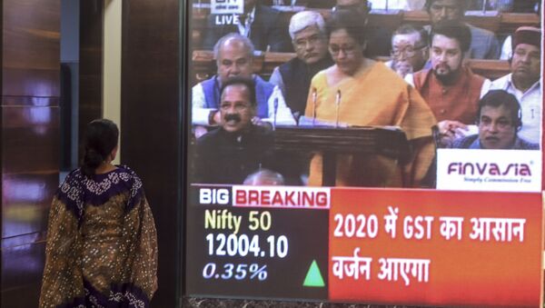A woman stands as she watches a screen displaying a television channel live broadcast of India's Finance Minister Nirmala Sitharaman (C on screen) presenting the 2020 union budget, at the Bombay Stock Market (BSE) in Mumbai on February 1, 2020.  - Sputnik International