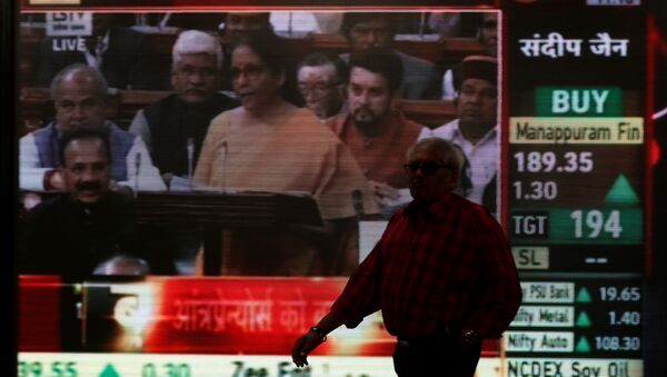 A man walks past a telecast of India's Finance Minister Nirmala Sitharaman presenting the budget inside the Bombay Stock Exchange  - Sputnik International