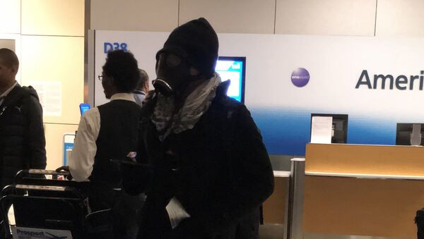 Passengers aboard an American Airlines flight waiting to take off from Dallas Fort Worth International Airport on Thursday were alarmed when they saw a man board wearing a gas mask - Sputnik International