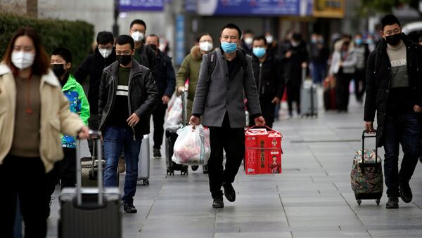 Passengers wearing masks walk outside the Shanghai railway station in Shanghai, China, as the country is hit by an outbreak of a new coronavirus, February 2, 2020 - Sputnik International