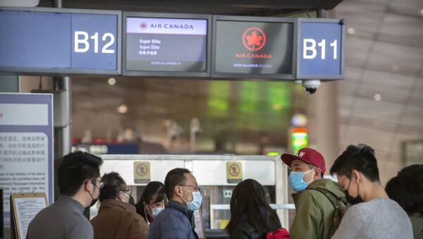 Travelers wearing face masks at the Air Canada check-in counters at Beijing Capital International Airport in Beijing - Sputnik International