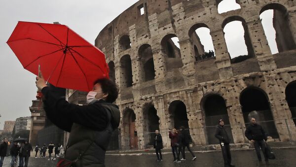 Турист в маске делает селфи перед римским Колизеем - Sputnik International