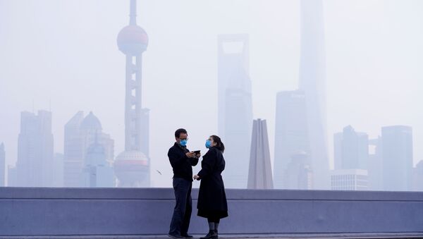 Люди в масках на мосту на фоне финансового района Пудун в Шанхае, Китай - Sputnik International