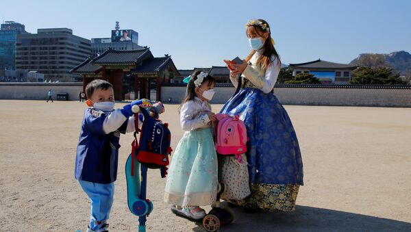 A woman and children wear masks to protect themselves against the new coronavirus in Seoul, South Korea, February 3, 2020.    - Sputnik International