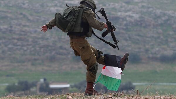 An Israeli soldier kicks a Palestinian flag during a protest against the US President Donald Trump’s Middle East peace plan in the Jordan Valley in the Israeli-occupied West Bank 29 January 2020 - Sputnik International