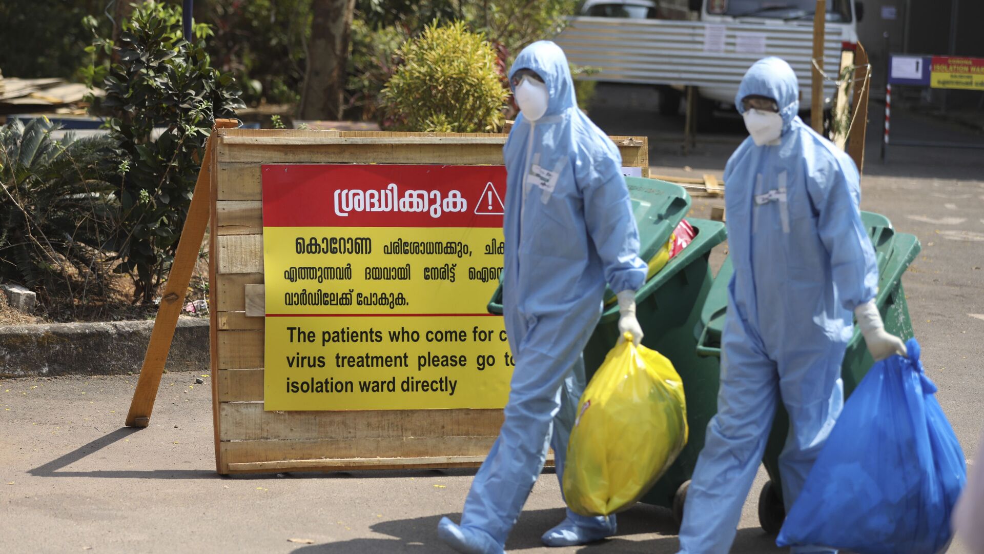 Indian workers walk with garbage after cleaning an isolation ward at a hospital for observing people suspected to have a new coronavirus infection in Kochi, Kerala state, India, Tuesday, Feb.4, 2020. - Sputnik International, 1920, 31.07.2022