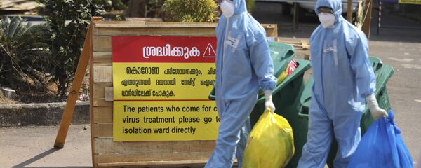 Indian workers walk with garbage after cleaning an isolation ward at a hospital for observing people suspected to have a new coronavirus infection in Kochi, Kerala state, India, Tuesday, Feb.4, 2020. - Sputnik International