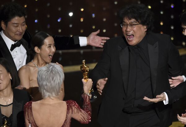 Bong Joon Ho, right, reacts as he is presented with the award for Best Picture for Parasite from presenter Jane Fonda at the Oscars on Sunday, 9 February 2020, at the Dolby Theatre in Los Angeles. Looking on from left are Kang-Ho Song and Kwak Sin Ae. - Sputnik International