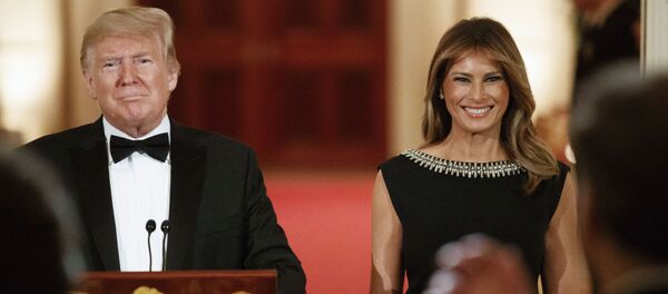 First lady Melania Trump smiles next to President Donald Trump as he arrives to speak at the Governors' Ball - Sputnik International