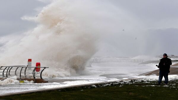 A man looks out to the sea as a wave crashes over the barrier onto the promenade in Blackpool, northern England, on February 10, 2020 as high winds brought by Storm Ciara continue - Sputnik International