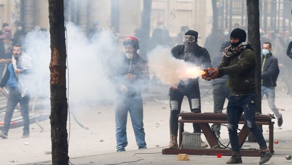 A protestor throws fireworks to the riot police during a protest seeking to prevent MPs and government officials from reaching the parliament for a vote of confidence, in Beirut, Lebanon February 11, 2020 - Sputnik International