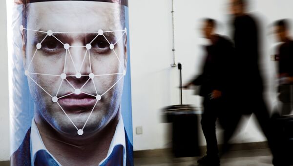 People walk past a poster simulating facial recognition software at the Security China 2018 exhibition - Sputnik International