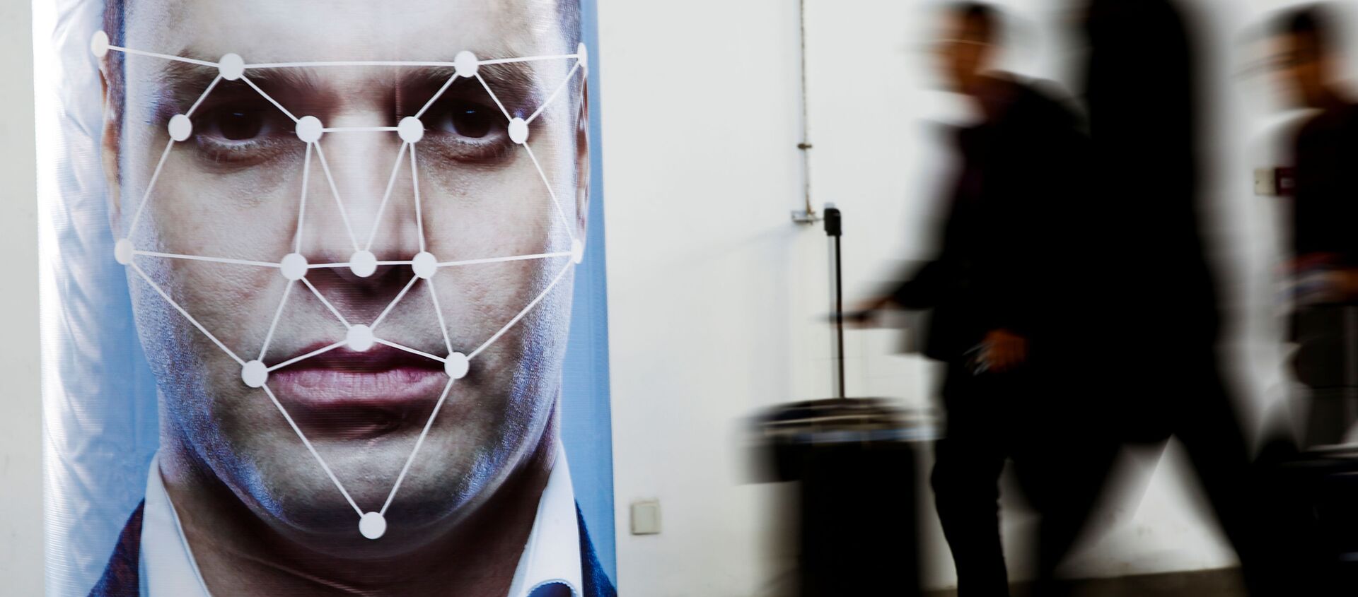 People walk past a poster simulating facial recognition software at the Security China 2018 exhibition - Sputnik International, 1920, 11.02.2020