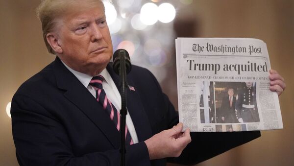  U.S. President Donald Trump holds up a copy of the Washington Post's front page showing news of Trump's acquitttal in his Senate impeachment trial, as he delivers a statement about his acquittal in the East Room of the White House in Washington, U.S., February 6, 2020.  - Sputnik International