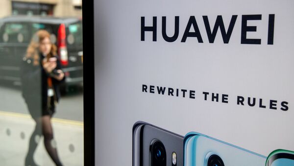 (FILES) In this file photo taken on April 29, 2019 A pedestrian walks past a Huawei product stand at an EE telecommunications shop in central London - Sputnik International