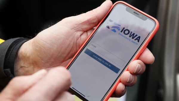 Precinct captain Carl Voss of Des Moines displays the Iowa Democratic Party caucus reporting app on his phone outside of the Iowa Democratic Party headquarters in Des Moines, Iowa, Tuesday, Feb. 4, 2020 - Sputnik International